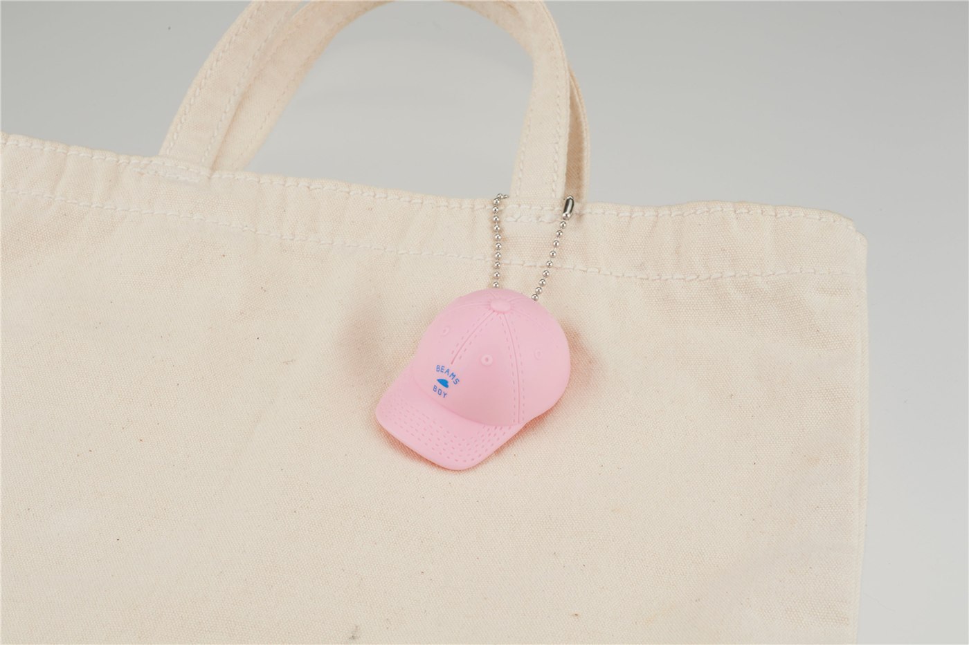 ピンクのキャップをトートバッグに取り付けた公式使用例。トートバッグは今回のガチャの付属品ではありません。